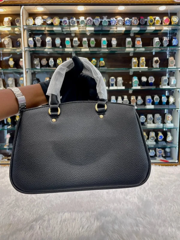 intgWUbG.jpg Front view of Coach sling bag for girls in black